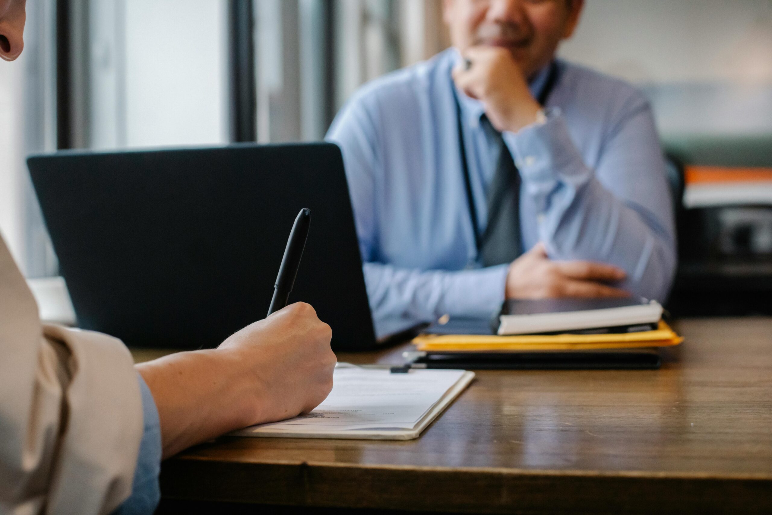 Vorteile für Unternehmen Crop anonymous female filling questionnaire when applying for job sitting in employer office